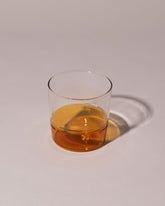 Ichendorf Milano Amber/Clear Light Colore Water Glass on light color background.