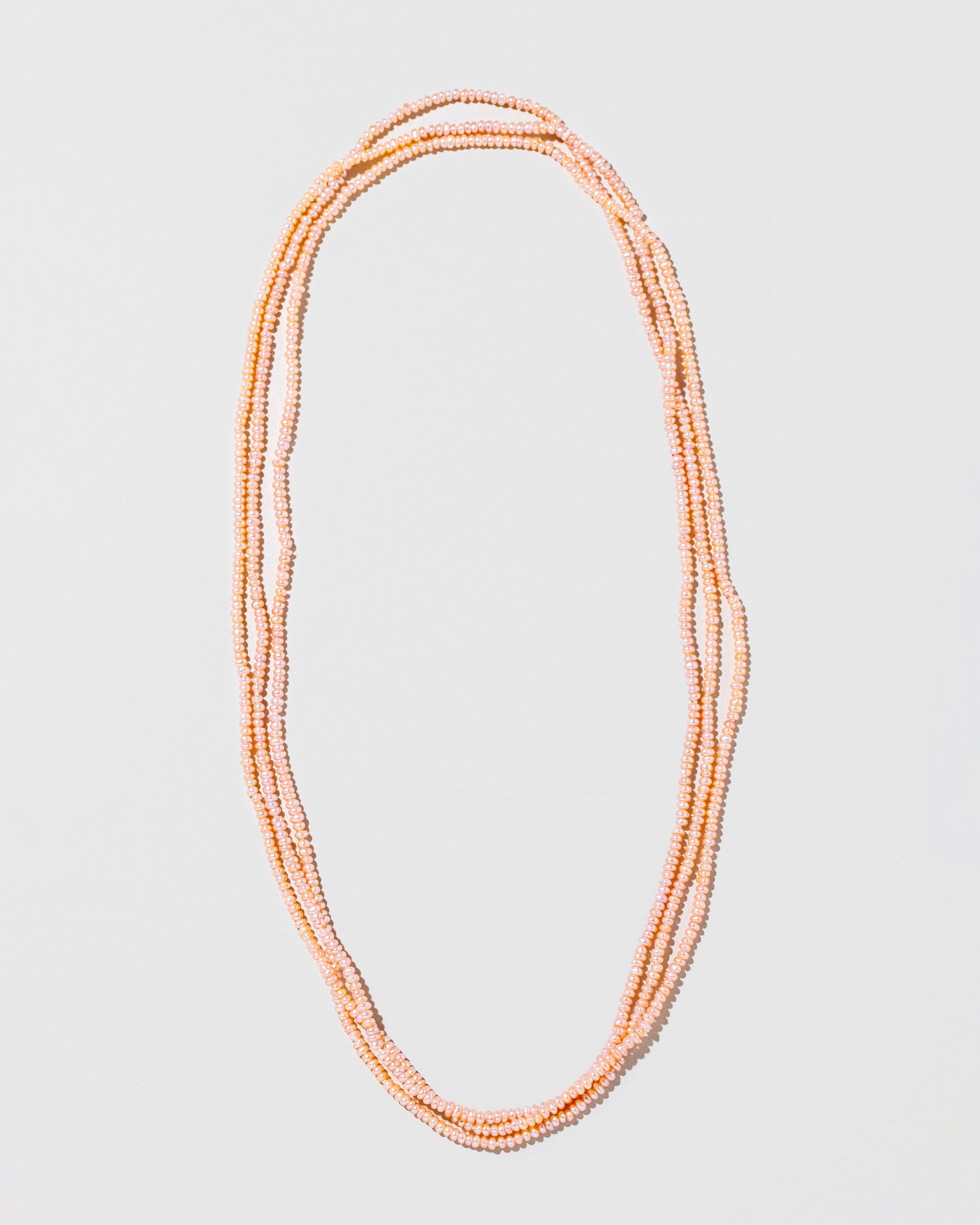  Seed Pearl Rope Necklace on light color background.