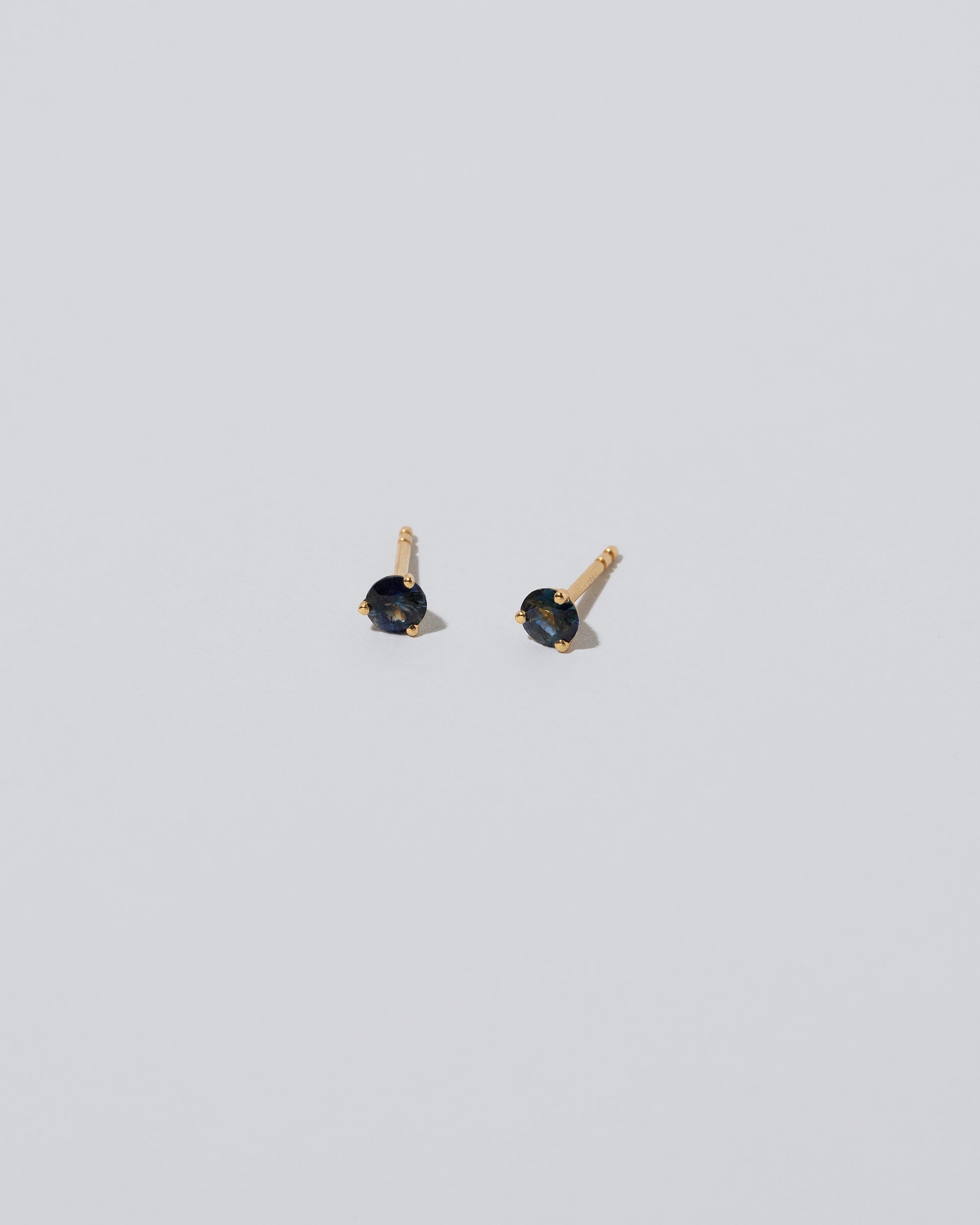 Product photo of Martini Stud Earrings - Blue & Yellow Sapphire on light dolor background. 
