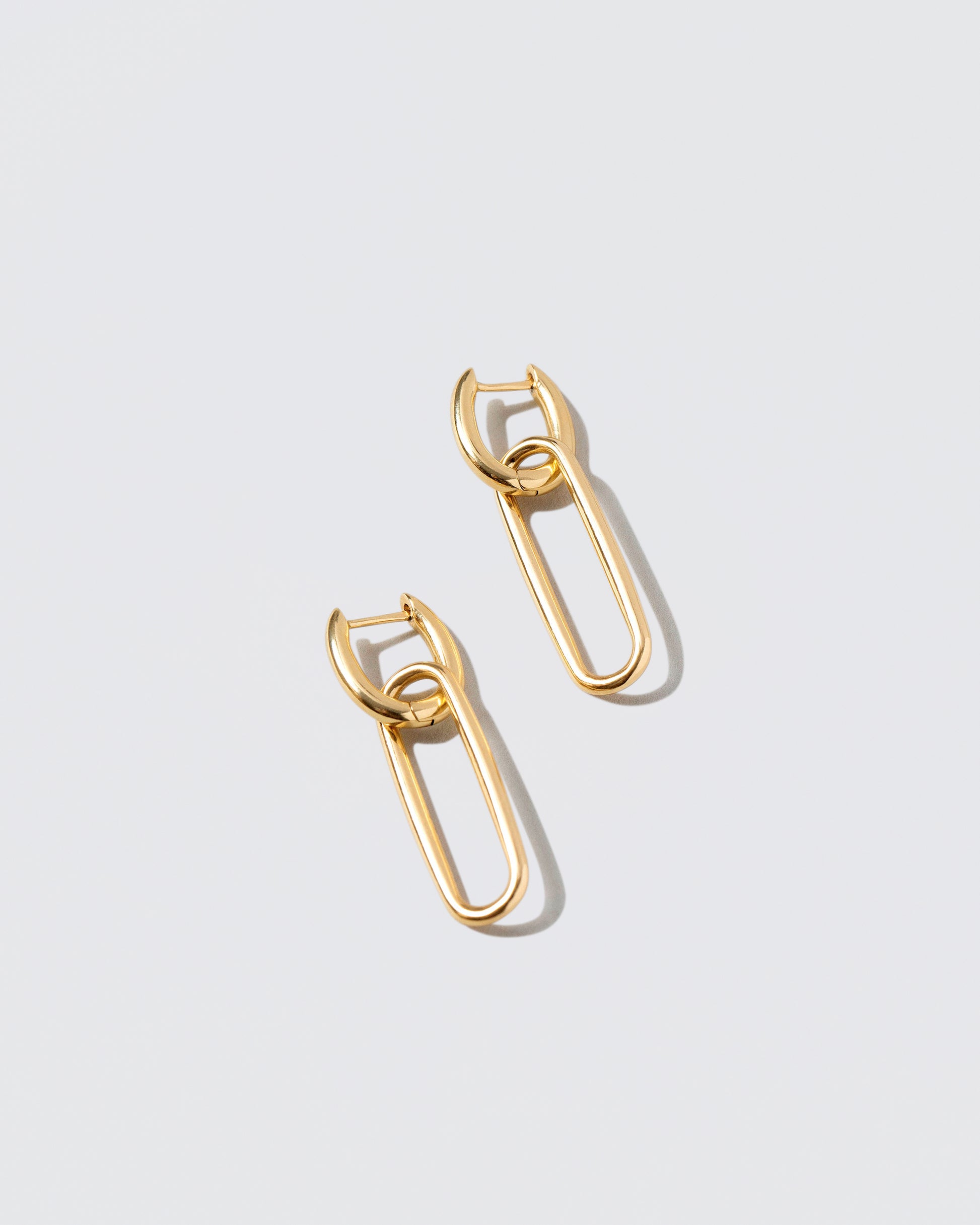 Link Huggie Hoop Earrings on light color background.