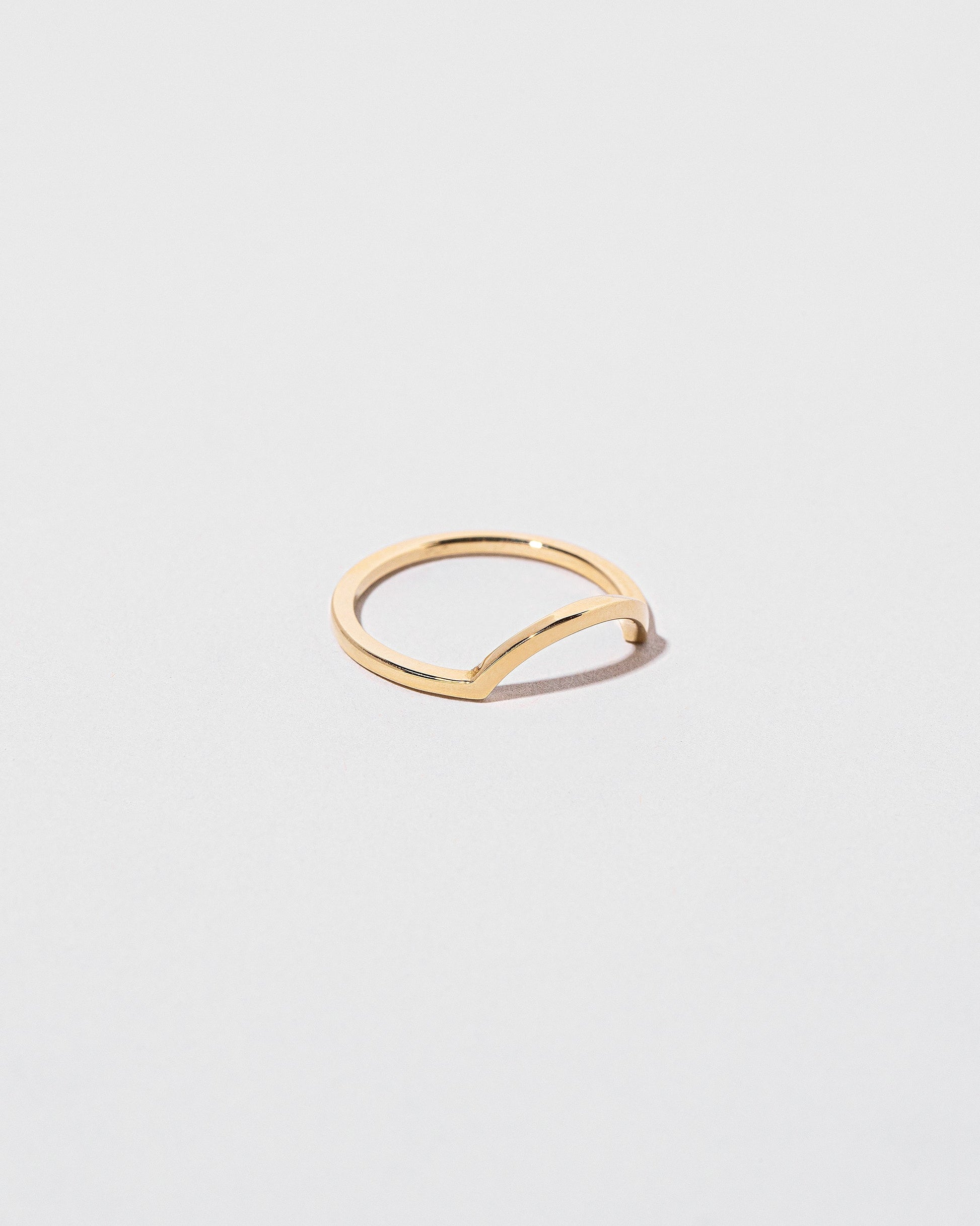 View from the side of the Gold Square Wire Curve Band on light color background.