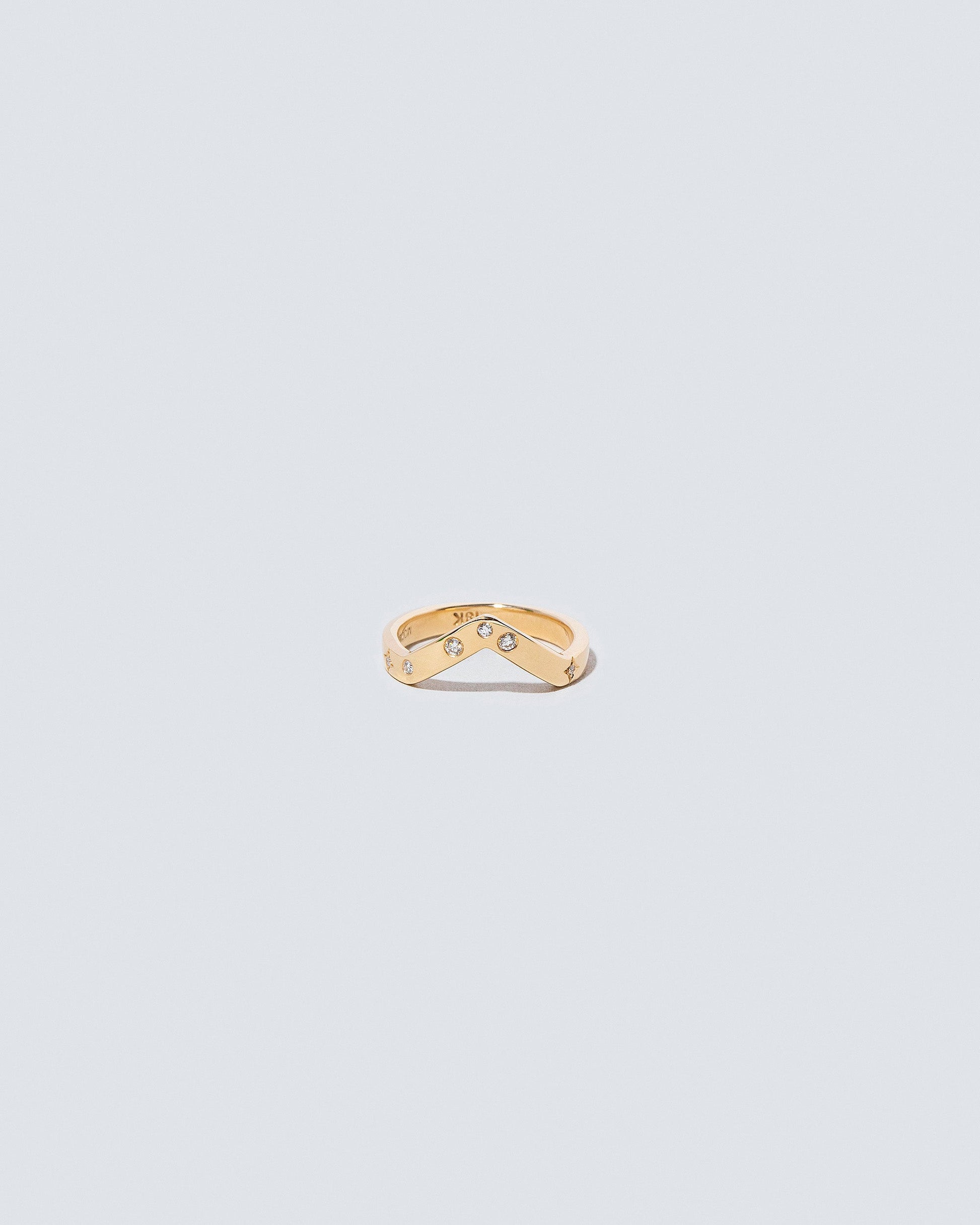 Yellow Gold Wide High Peak Band with white diamond little array added on light color background.