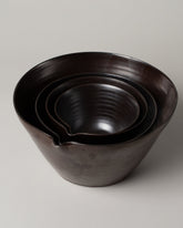 Closeup details of a group of Eric Bonnin Gunmetal Kam Bowl #1, Kam Bowl #2, Kam Bowl #3, Kam Bowl #1/2 and Kam Bowl #4 on light color background.