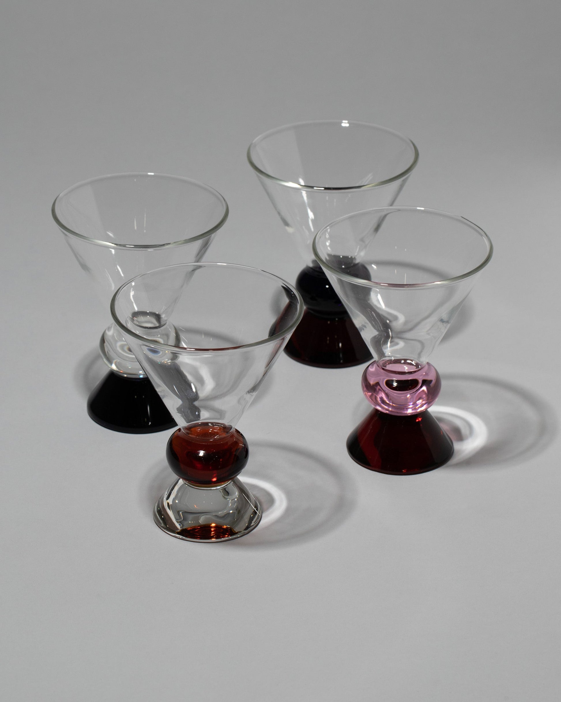 Group of Sophie Lou Jacobsen Amber & Clear, Clear & Blue, Pink & Amber and Blue & Amber Totem Glasses on light color background.