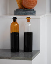 Styled image featuring Ichendorf Milano Black/Clear and Black/Amber Light Colore Bottles.
