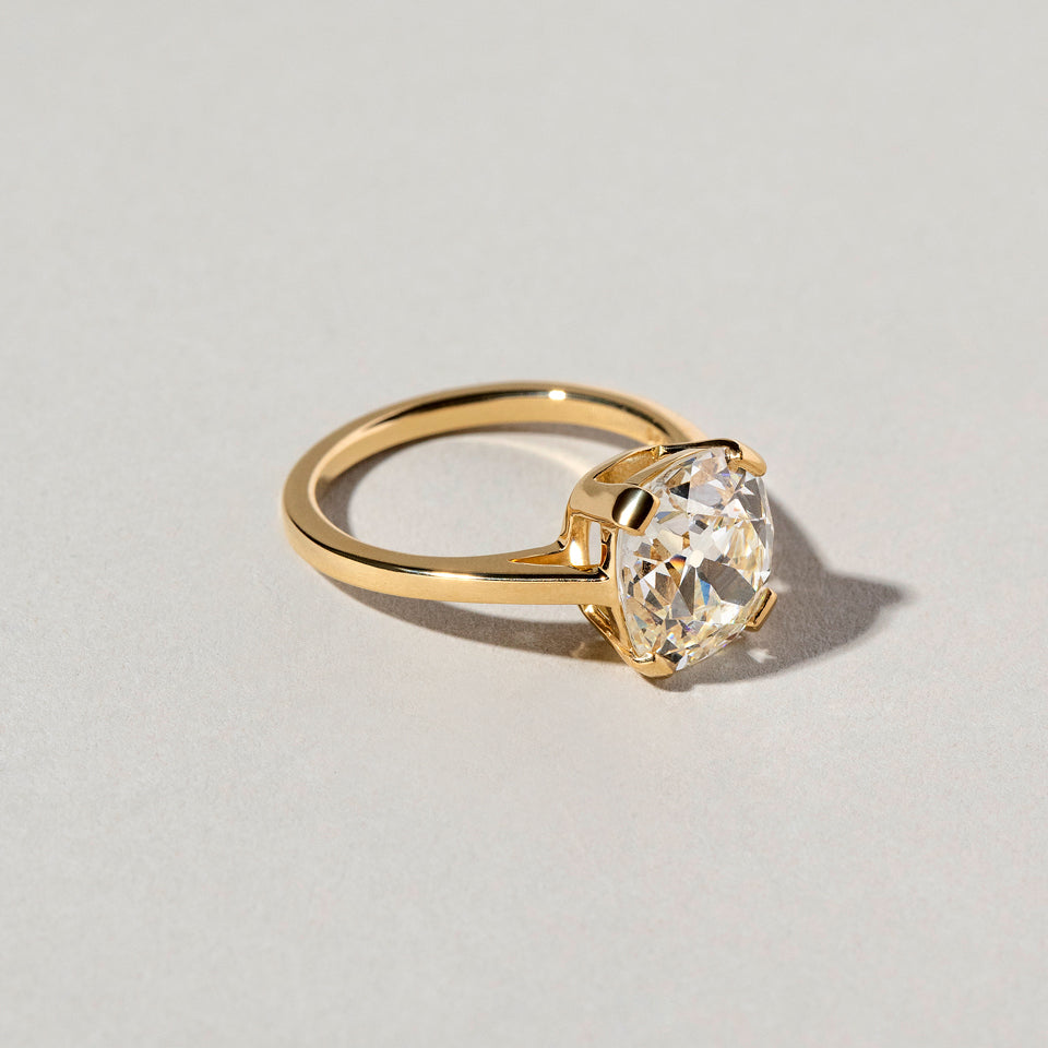 product_details:: Cushion Cut Diamond Solitaire Ring on light color background.
