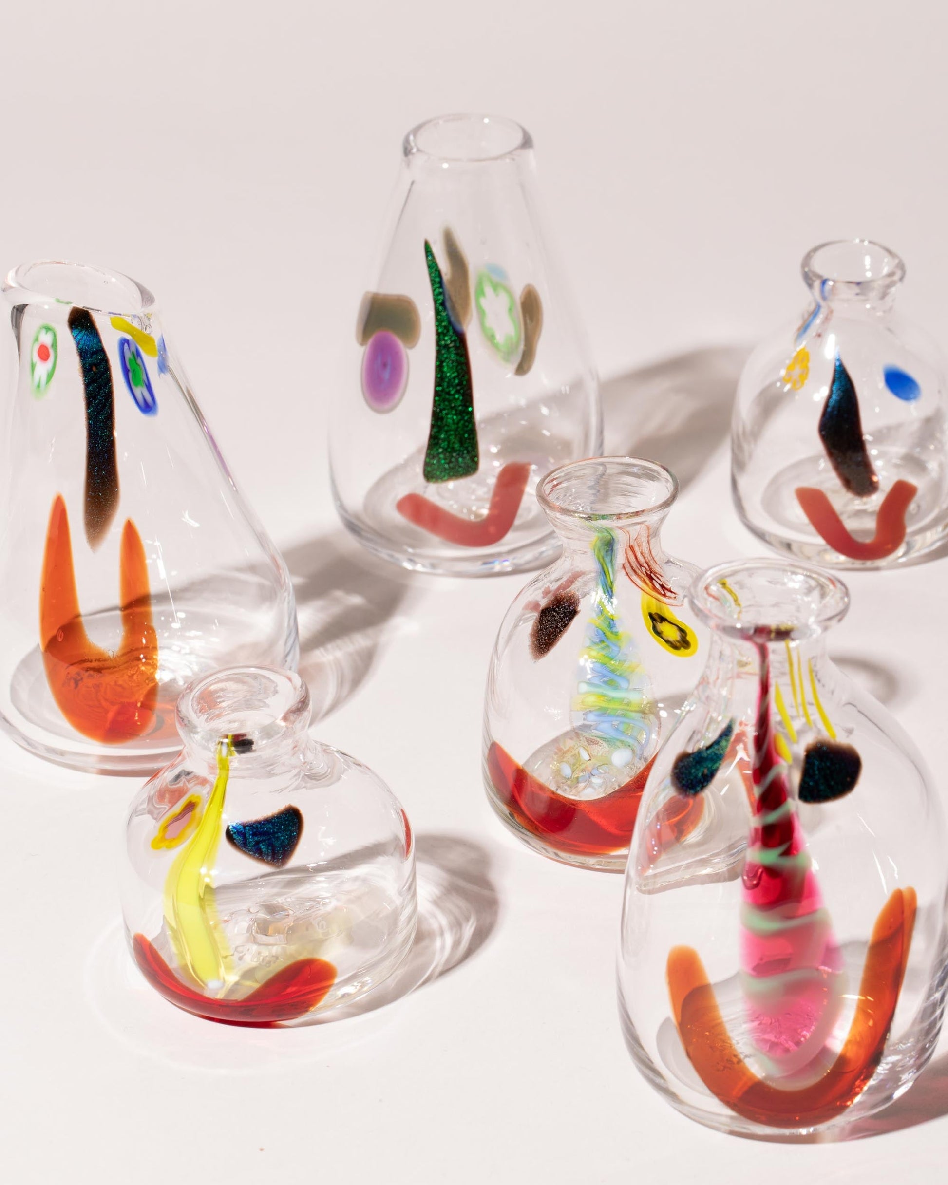 Group of FACEVESSEL Bud Vases on light color background.