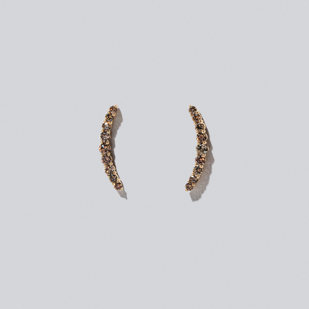 product_details::Crescent Ear Climber Stud Earrings - Cognac Diamond on light colored background.