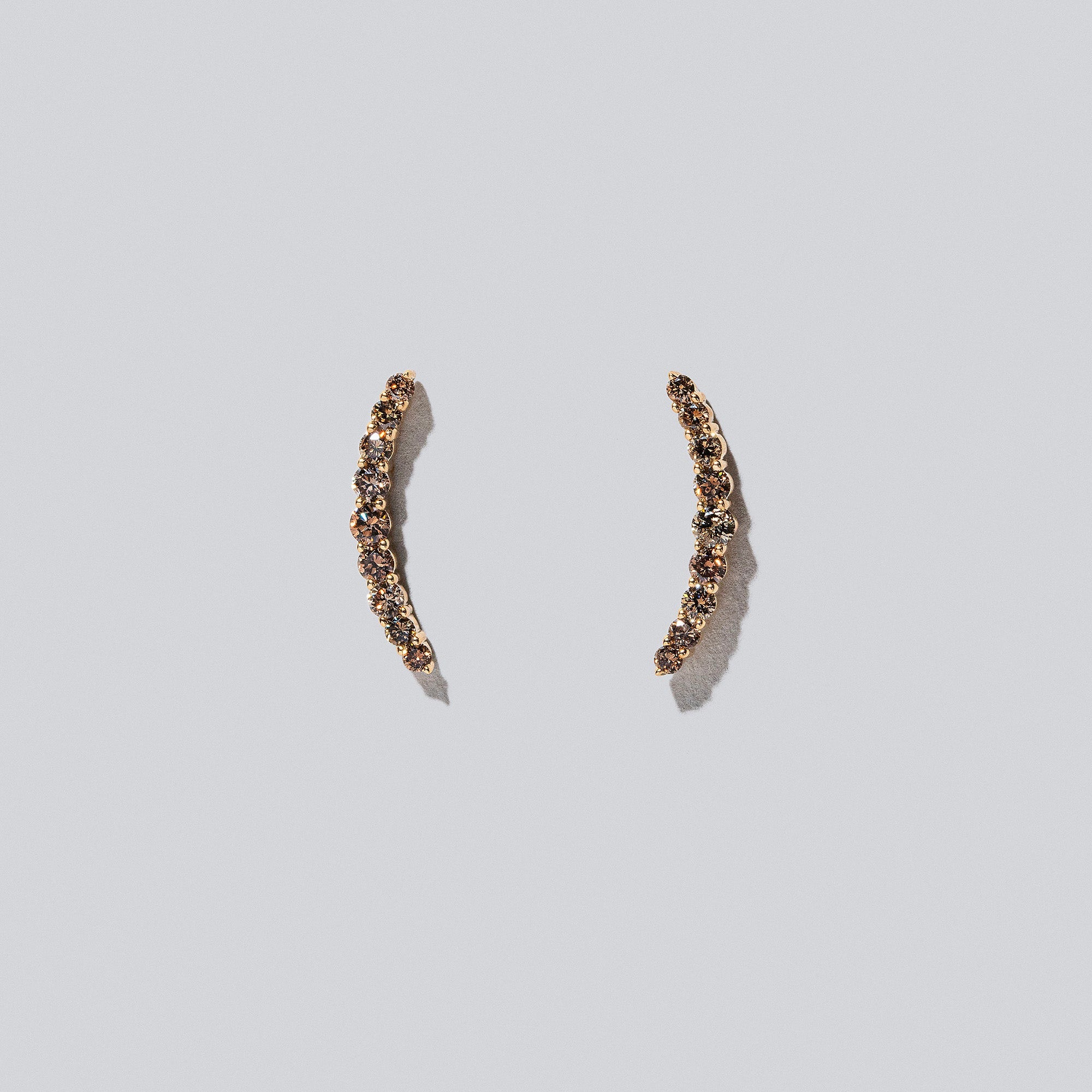 product_details::Crescent Ear Climber Stud Earrings - Cognac Diamond on light colored background.