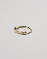 View from the side of the Gold White Diamond Eleven Trillion Ring on light color background.
