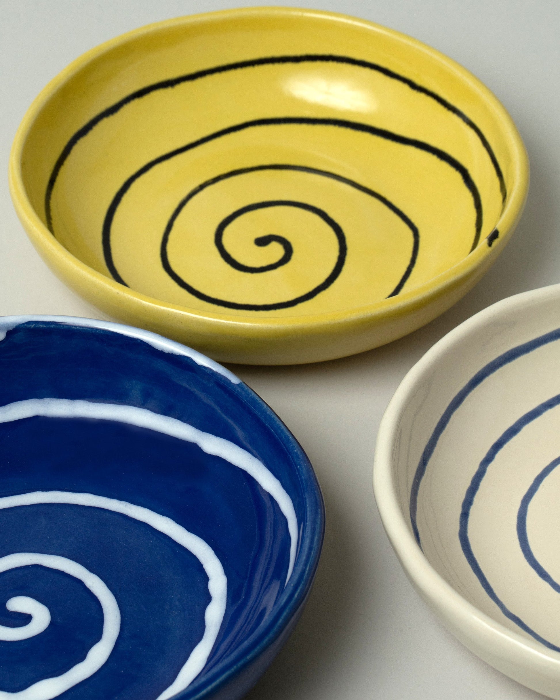 Closeup details of a group of Casa Veronica Azul, Sol and Leche Vida Bowls on light color background.