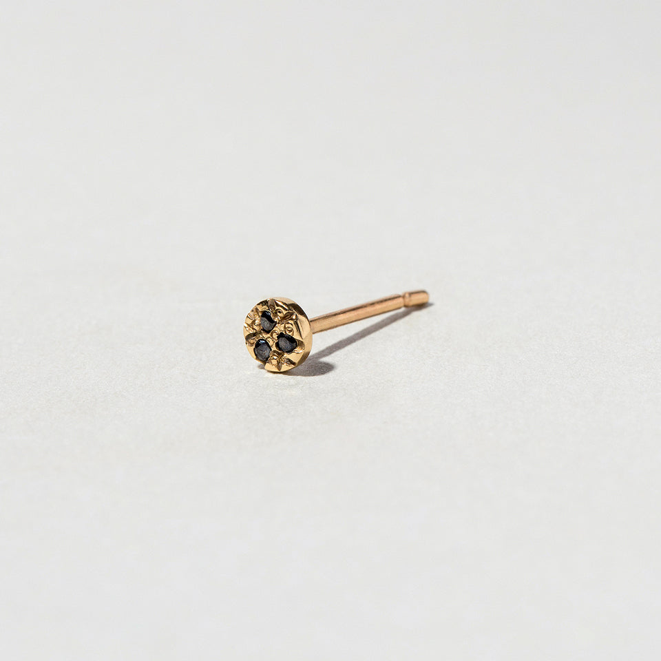 product_details::Closeup details of the Gold Black Diamond Circle Stud Earring Single on light color background.