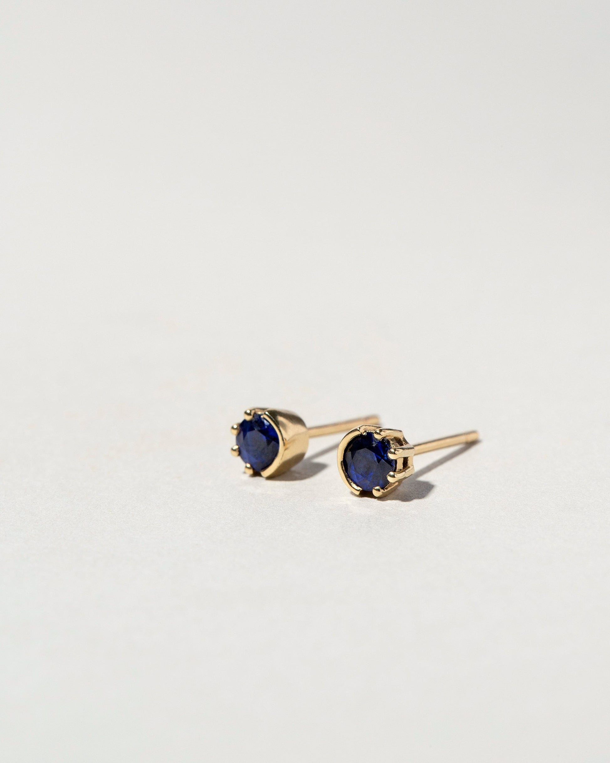 Sapphire Sun & Moon Stud Earrings on light color background.
