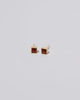 Square Frame Stud Earrings in Garnet on light color background.