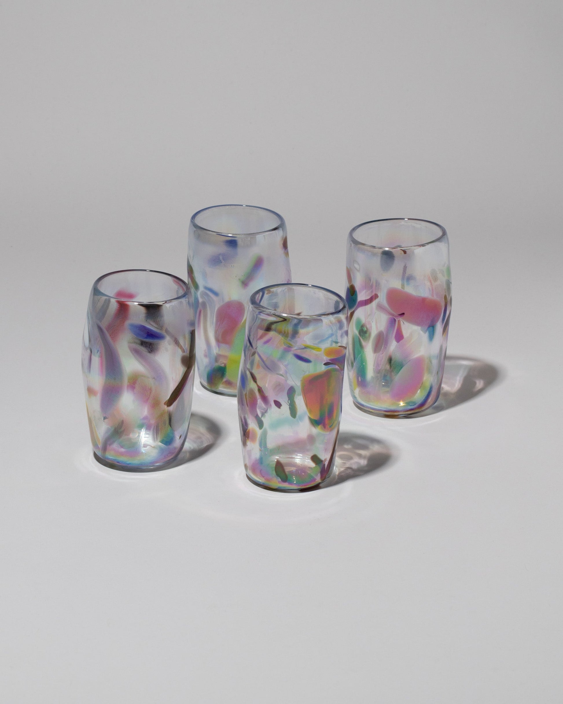 Group of Sirius Glassworks Iridescent Nassau Tumblers on light color background.