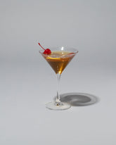 Spills Manhattan Martini on light color background.