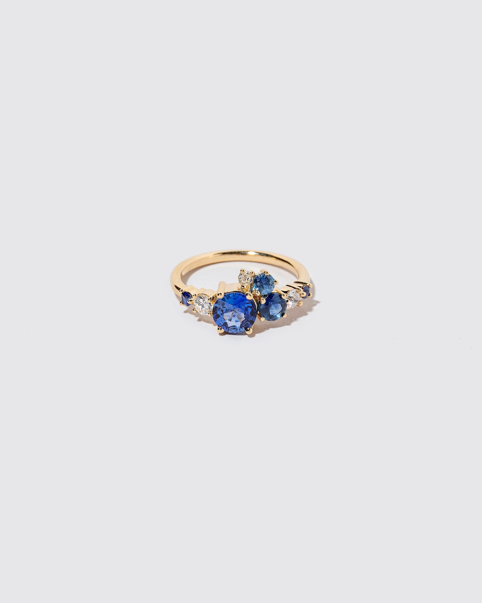 Limited-edition blue sapphire and white diamond Luna Ring on light color background.