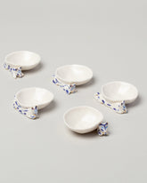Group of Eleonor Boström Blue Spots and Black Spots Mini Cat Dishes on light color background.