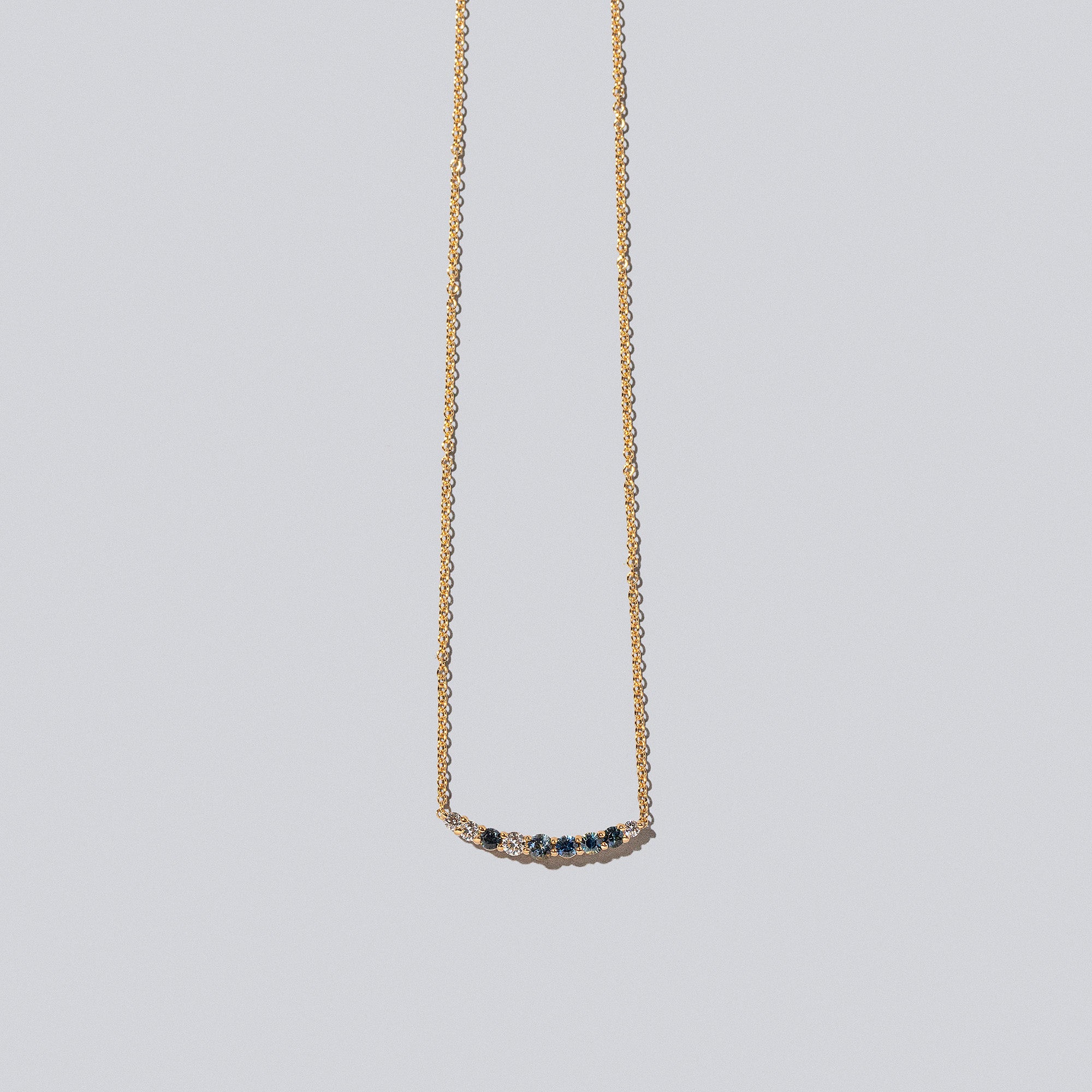 product_details::Sapphire & White Diamond Crescent Necklace on light color background.