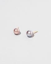 Closeup details of the Soft Landscape Earrings, shown as studs, on light color background.