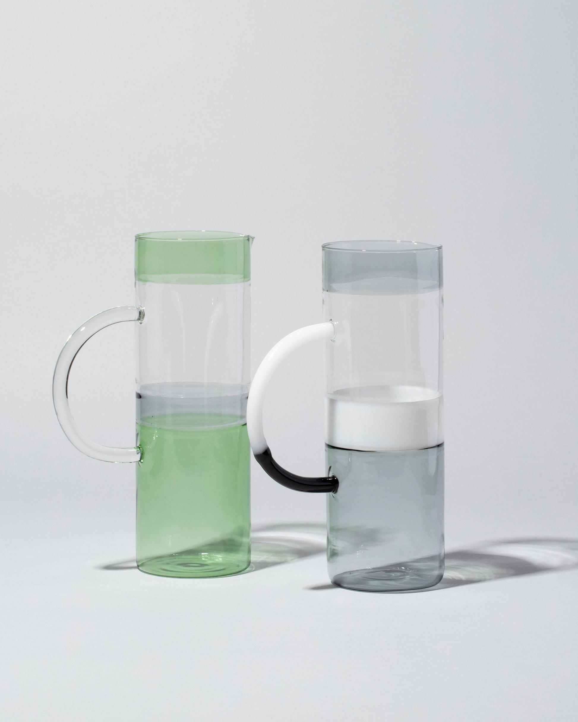 Group of Ichendorf Milano Smoke/White/Clear and Green/Smoke/Clear Tequila Sunrise Jugs on light color background.