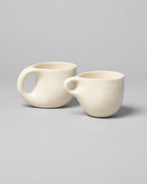 Group of Dust and Form Ritual Mug and Small Cream Comfort Mugs on light color background.