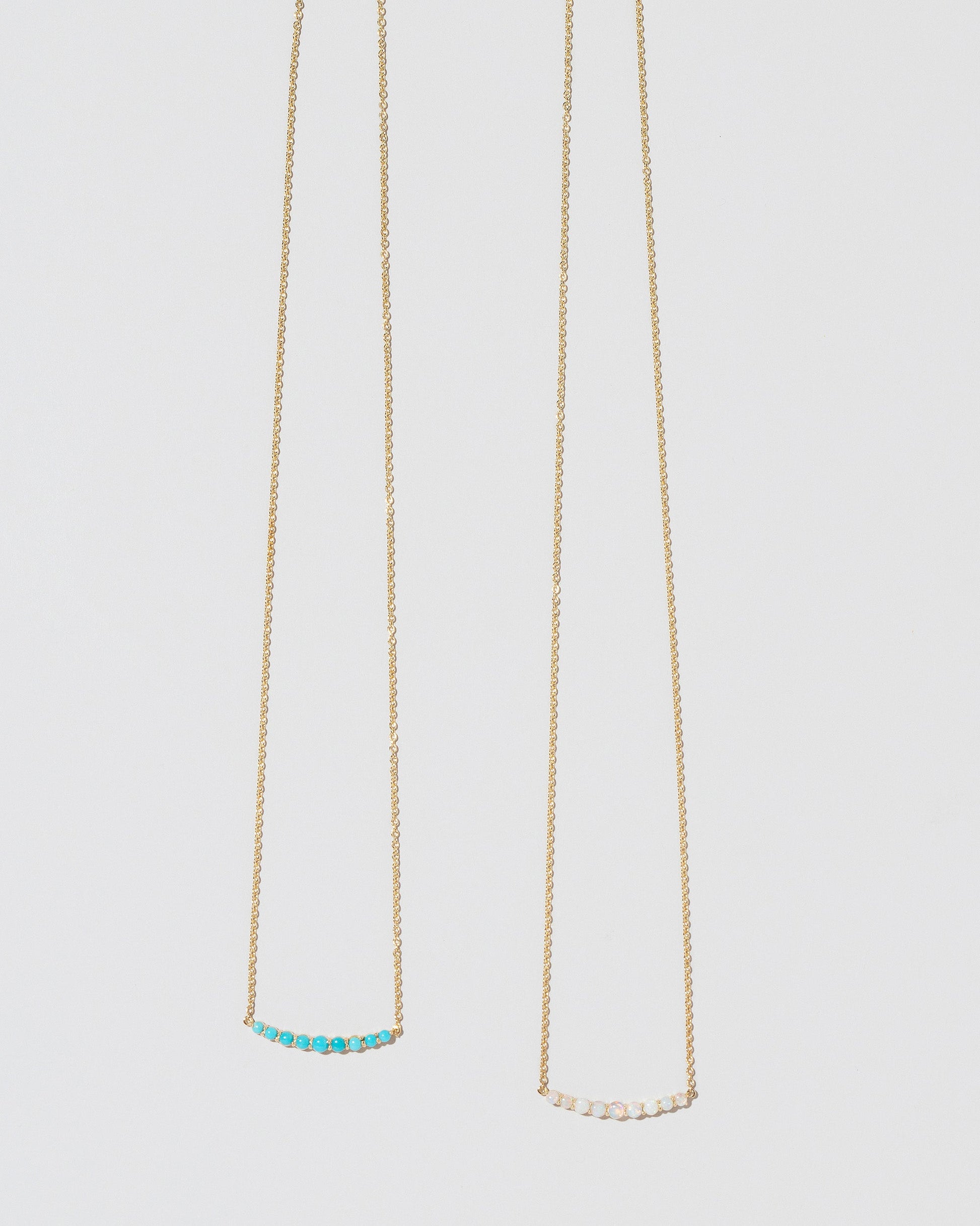 Crescent Necklaces on light colored background.