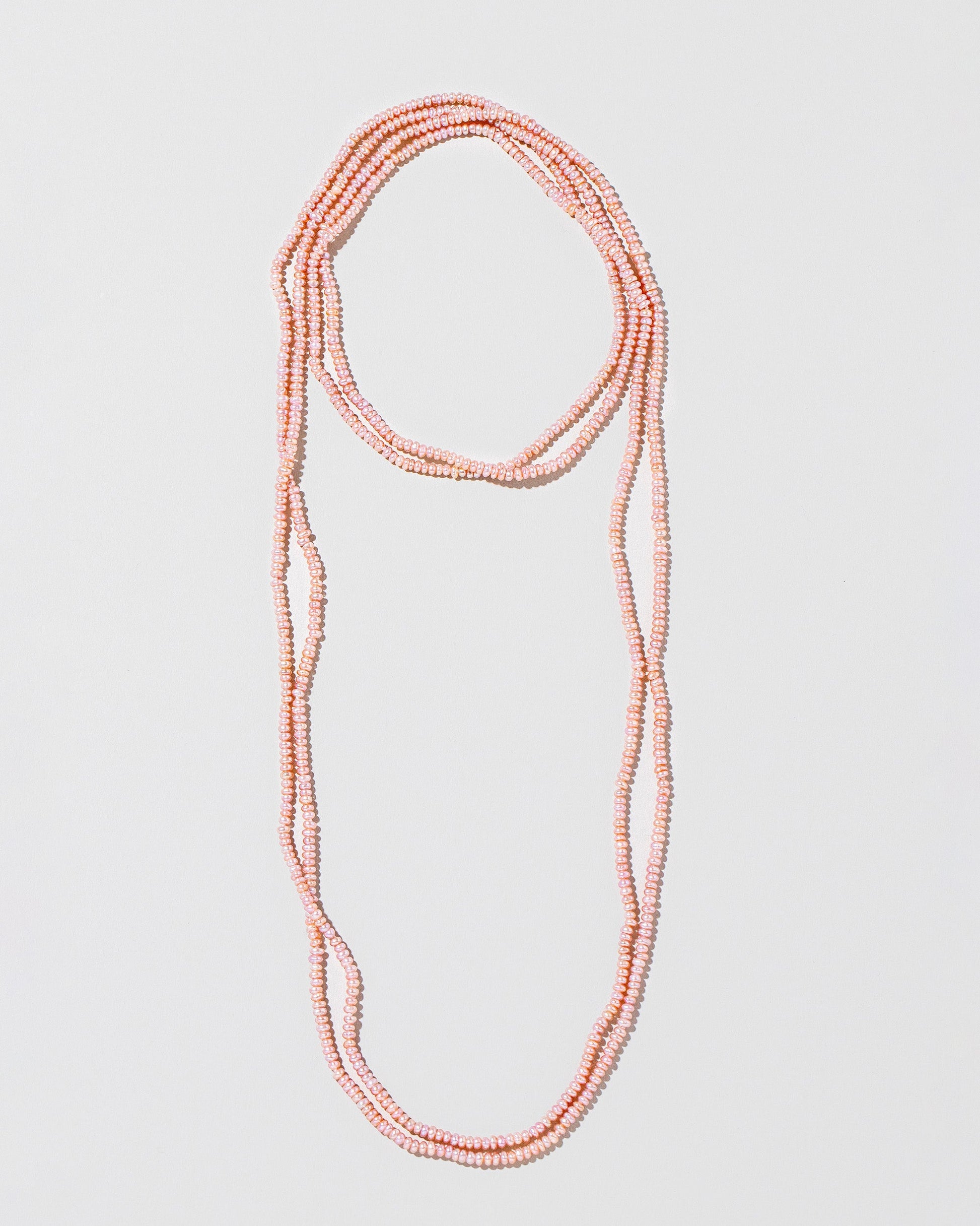  Seed Pearl Rope Necklace on light color background.