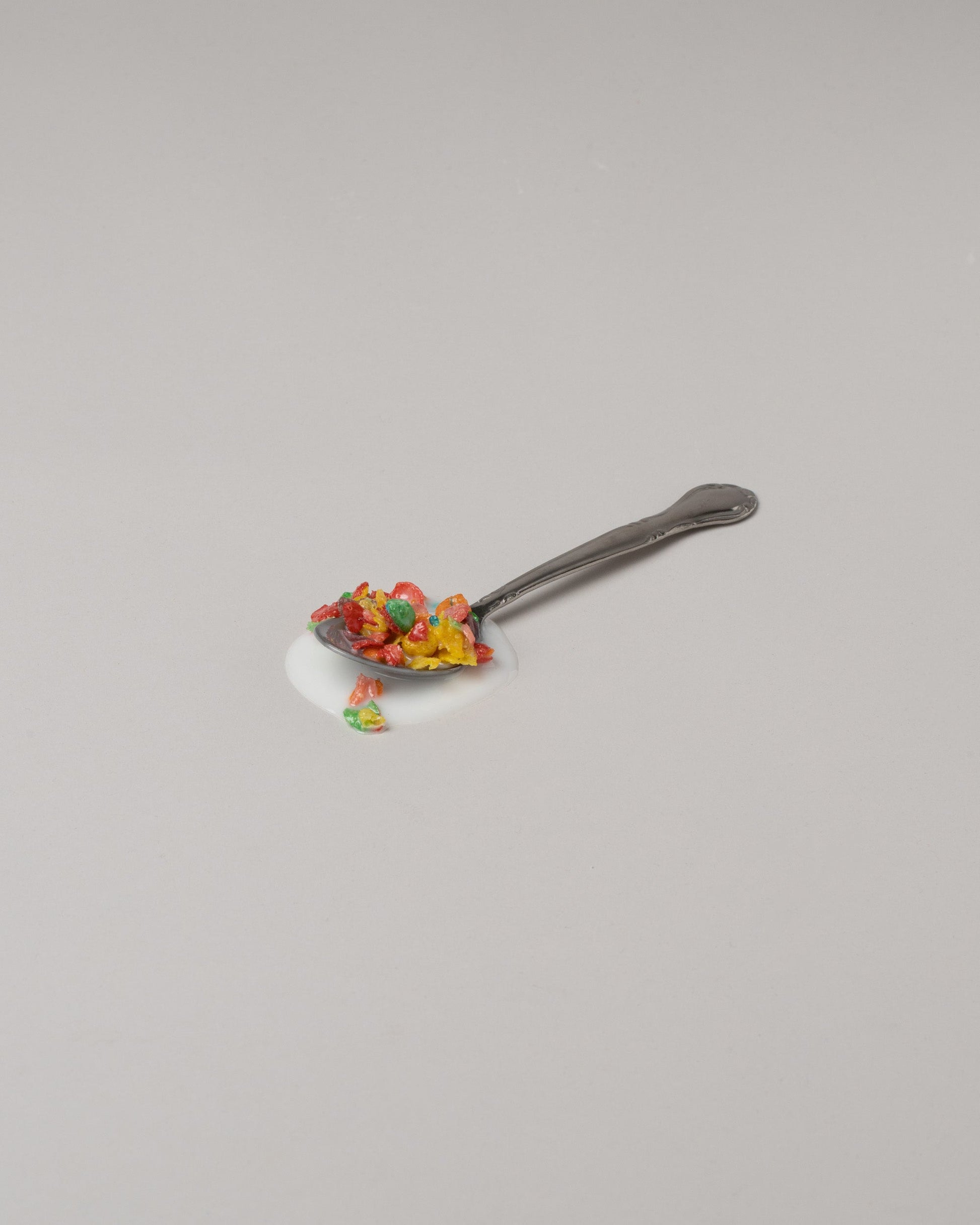 Spills Fruity Pebbles Spoon on light color background.