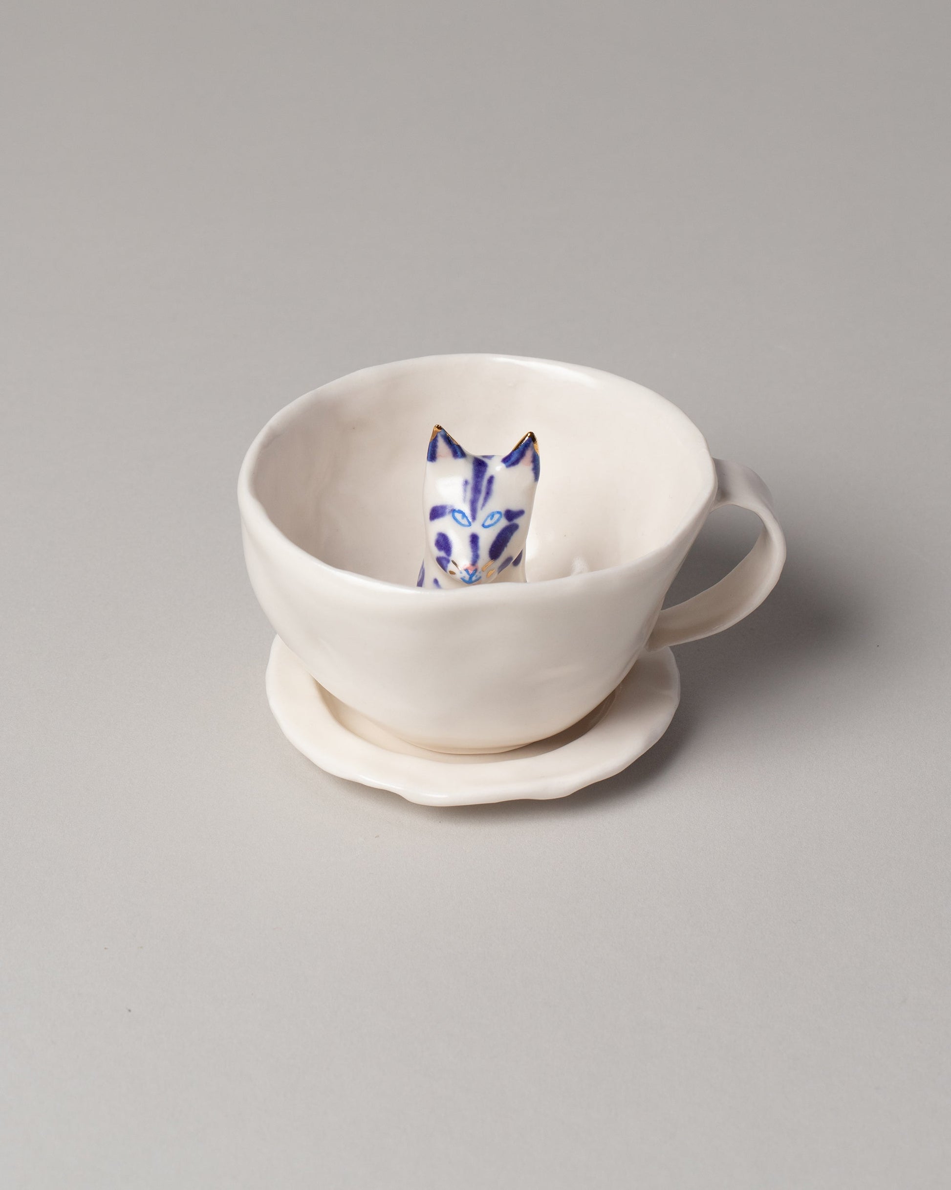 Eleonor Boström Blue Spots Cat Tea Cup with Saucer on light color background.