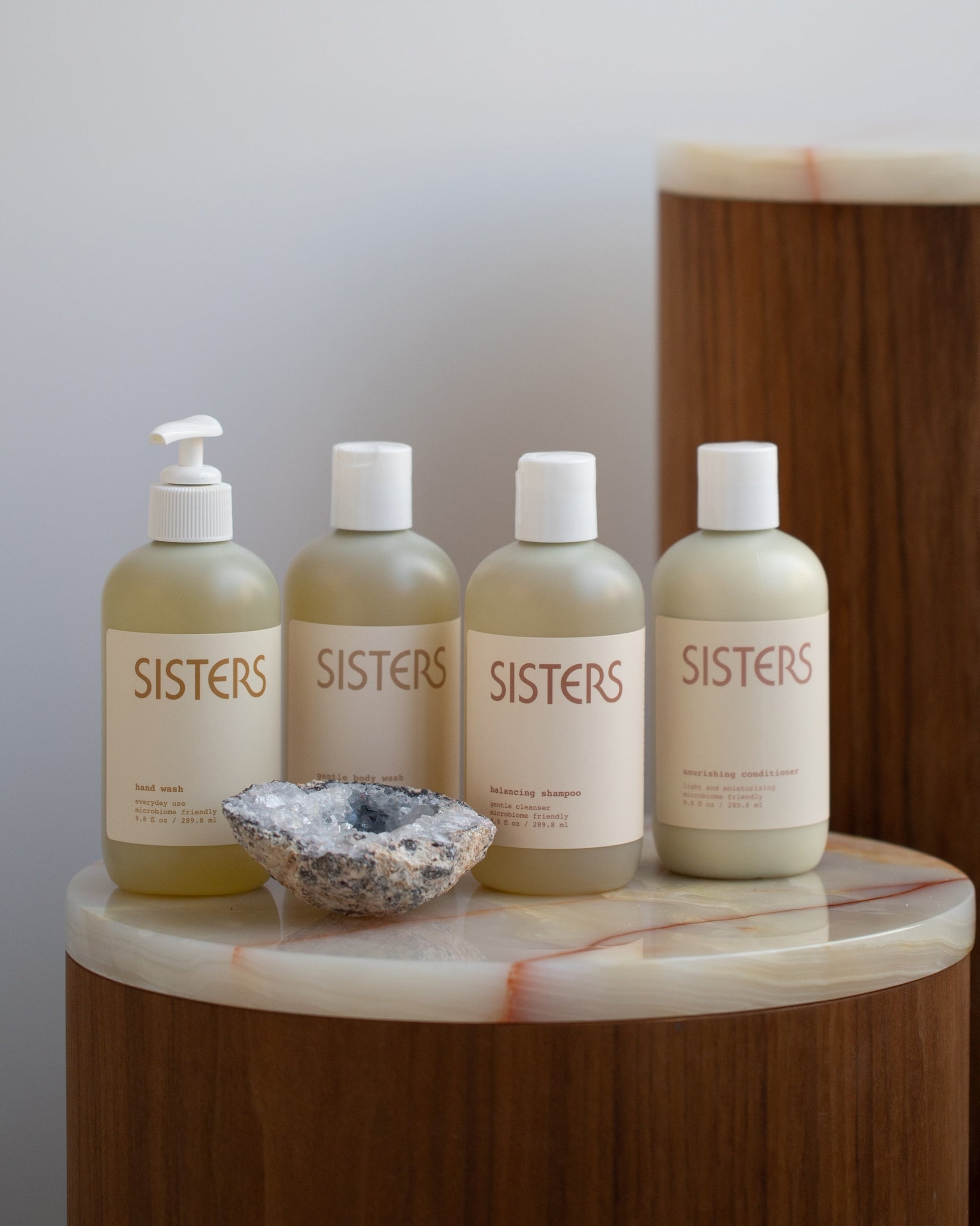 Styled image of the Sisters Body Hand Soap, Gentle Body Wash, Balancing Shampoo and Nourishing Conditioner.