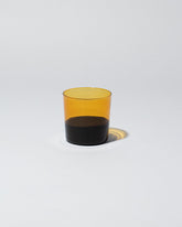 Ichendorf Milano Black/Amber Light Colore Water Glass on light color background.