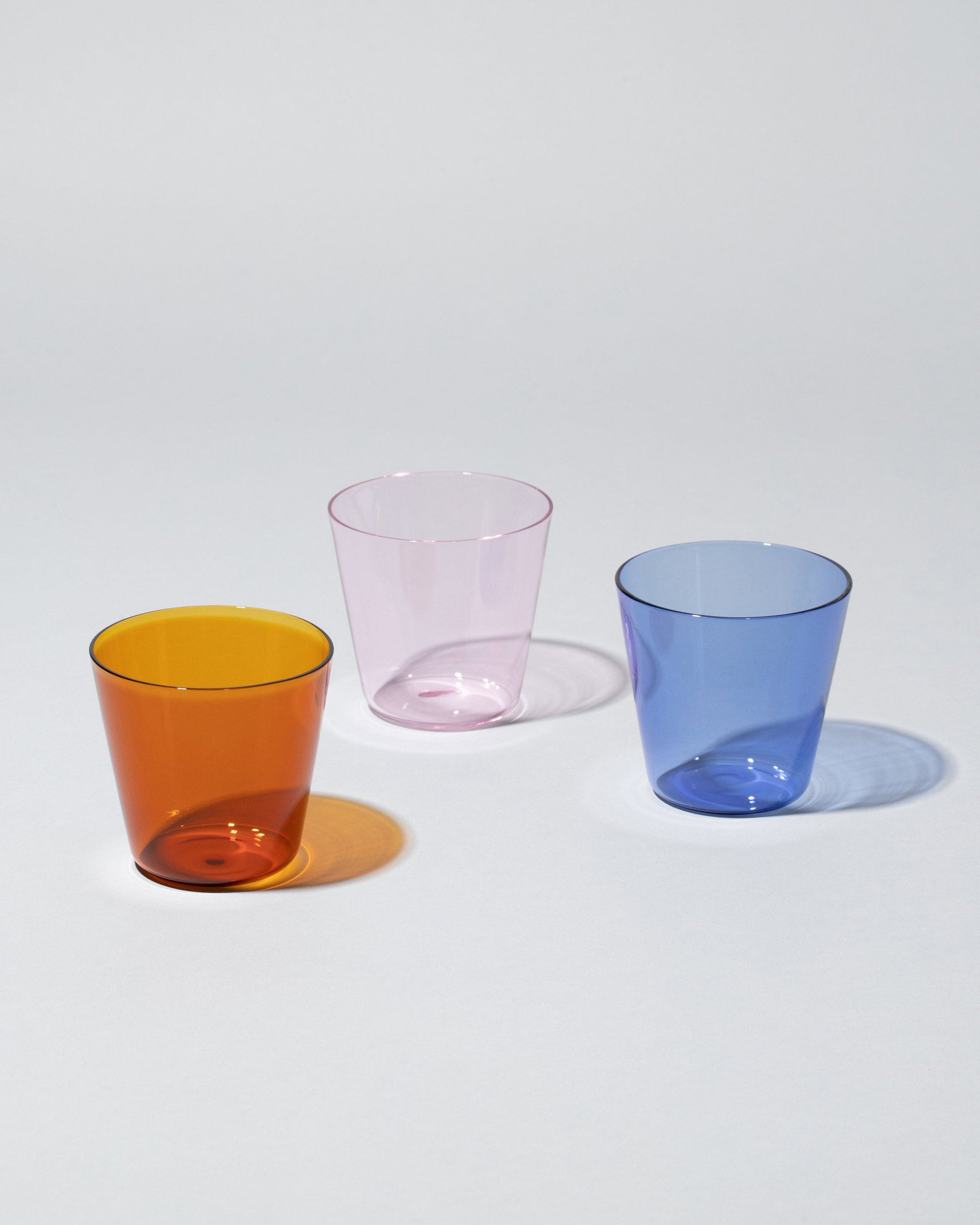Group of Ichendorf Milano Pink, Light Blue and Amber High Rise Tumblers on light color background.