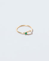 View from the side of the Diamond & Emerald Teardrop Ring on light color background.