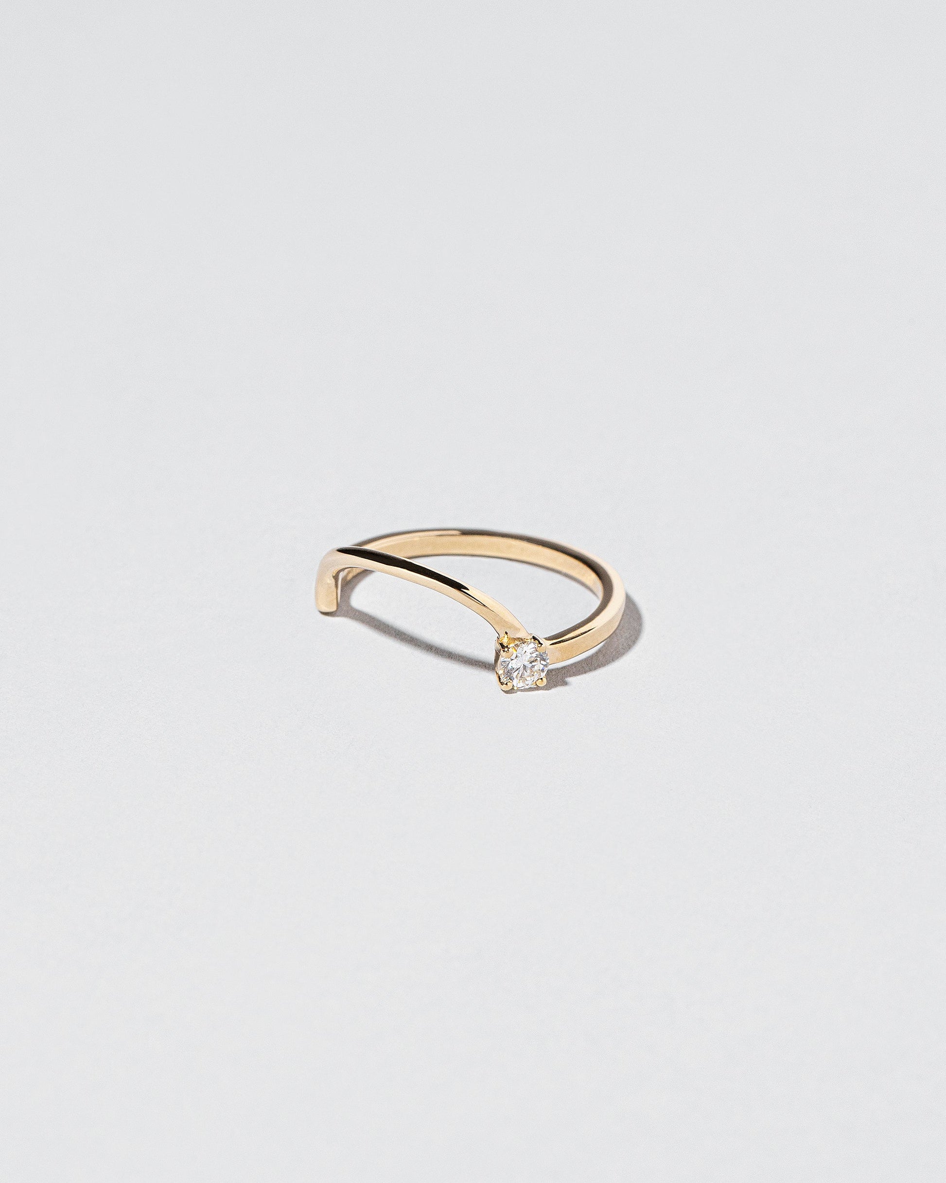 View from the side of the Yellow Gold White Diamond Half Hoop Band on light color background.
