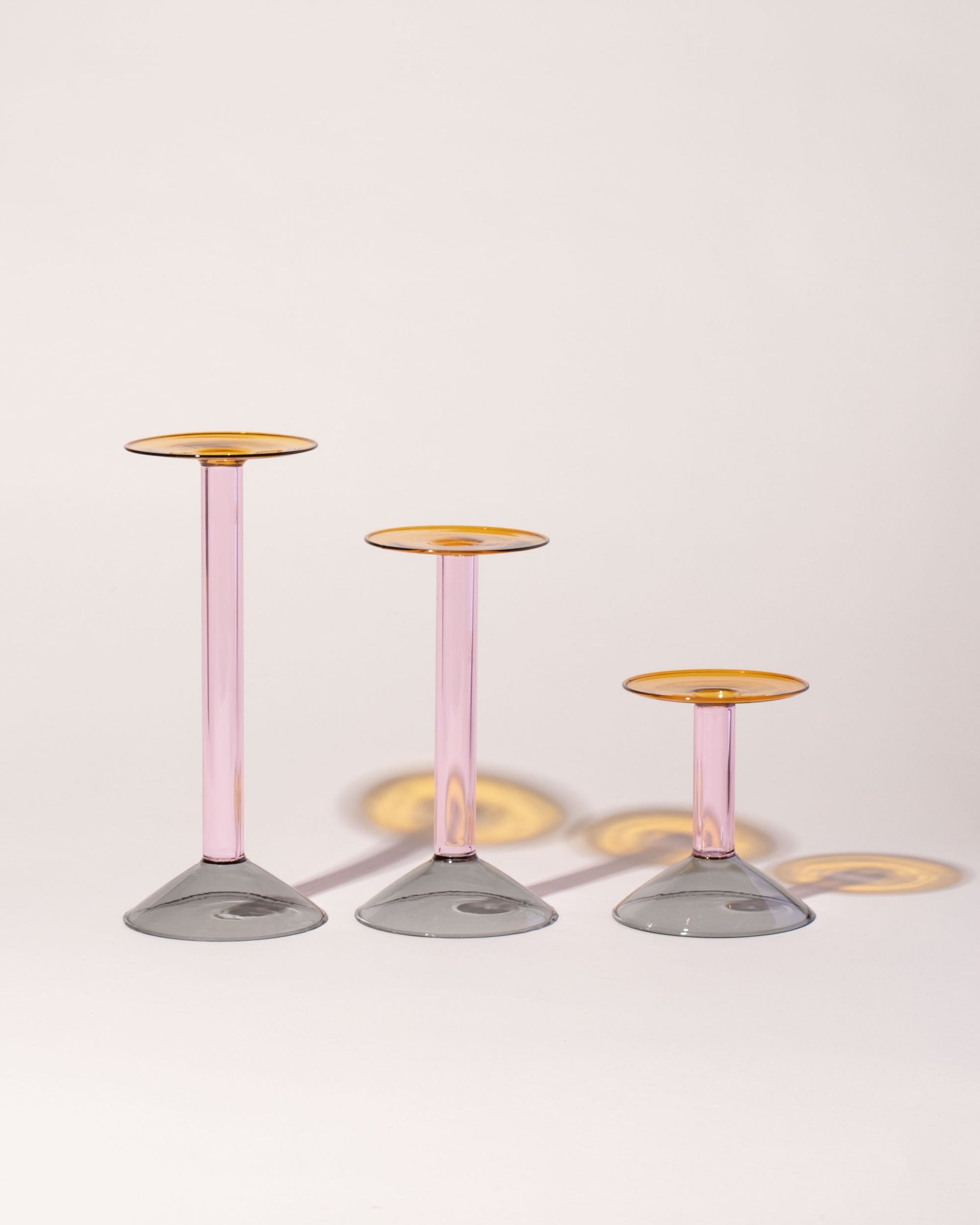 Group of Ichendorf Milano Small, Medium and Large Grey/Pink/Amber Rainbow Candleholders on light color background.