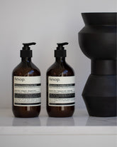 Styled photo featuring Aesop Resurrection & Reverence Hand Balms. 