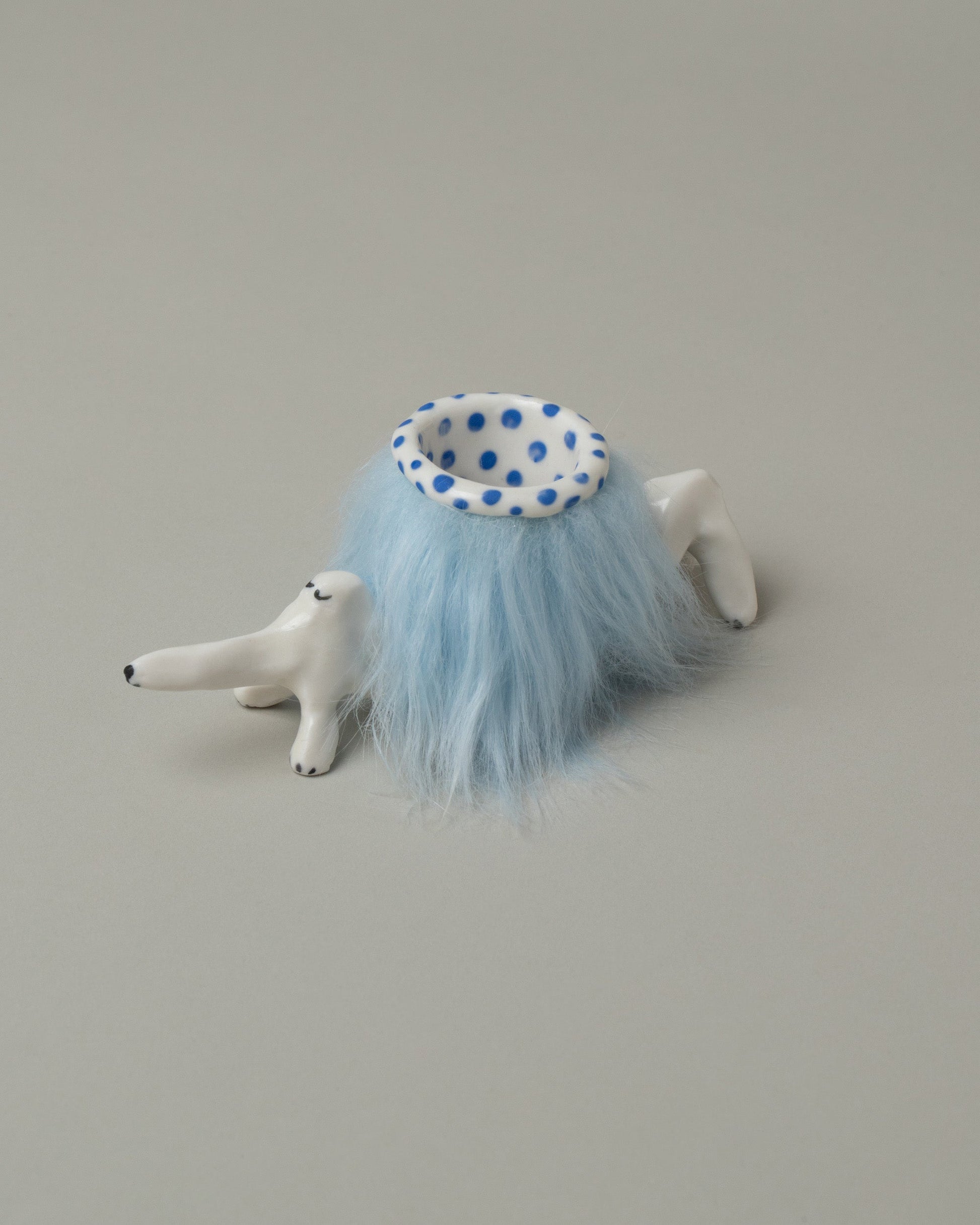 Closeup detail of the Eleonor Boström Blue Furry Baggage Dog on light color background.