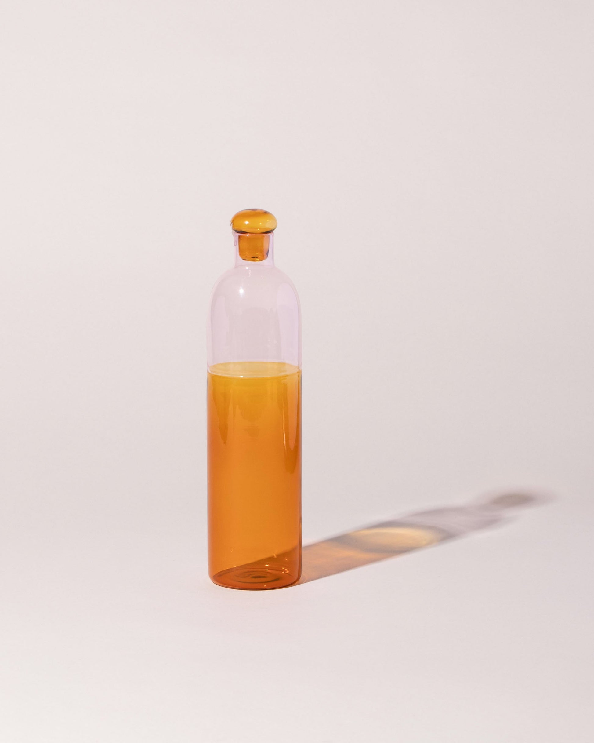 Ichendorf Milano Pink/Amber Light Colore Bottle on light color background.