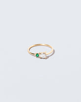 Diamond & Emerald Teardrop Ring on light color background.
