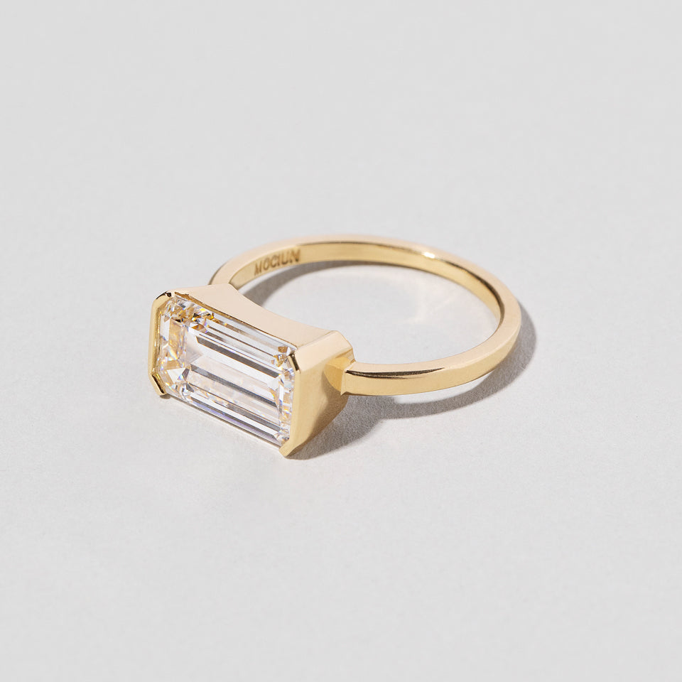 product_details:: Emerald Cut Diamond Solitaire Ring on light color background.