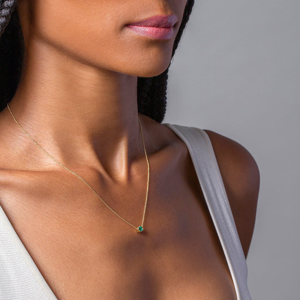 product_details::Emerald Sun & Moon Necklace on model.