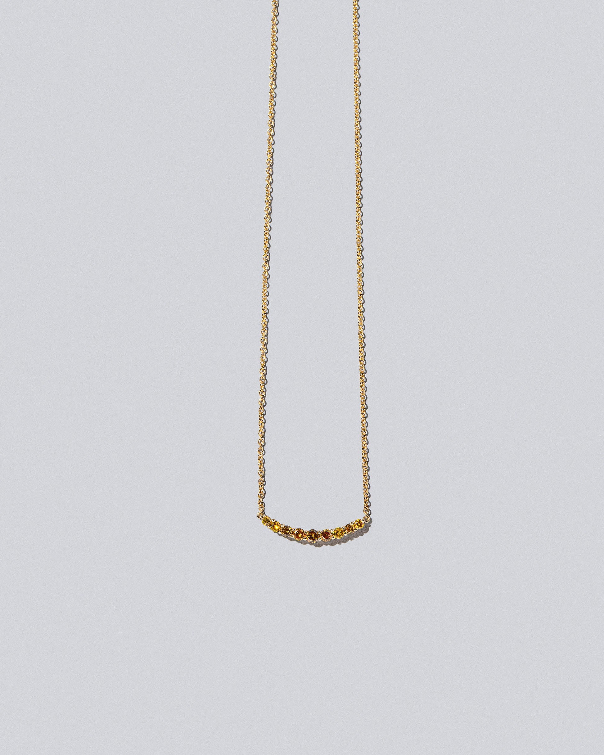Crescent Necklace - Yellow Diamond on light colored background.