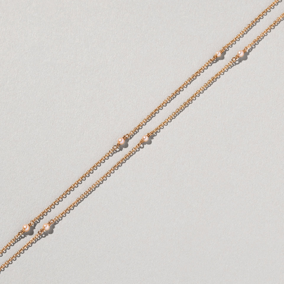 product_details:: Natural Pink Seed Pearl Necklace on light color background.